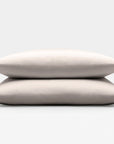 Two beige sand pillows stacked on a light gray background