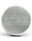 Silver shampoo box tin with 'arista ayurveda' branding on a white background