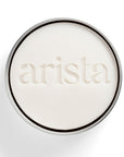 round shampoo bar holder box with shampoo bar inside with 'arista' branding on a white background