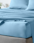 bambaw cozy bamboo bed sheets close up on a bed with fitted sheets and pillows in light blue colour
