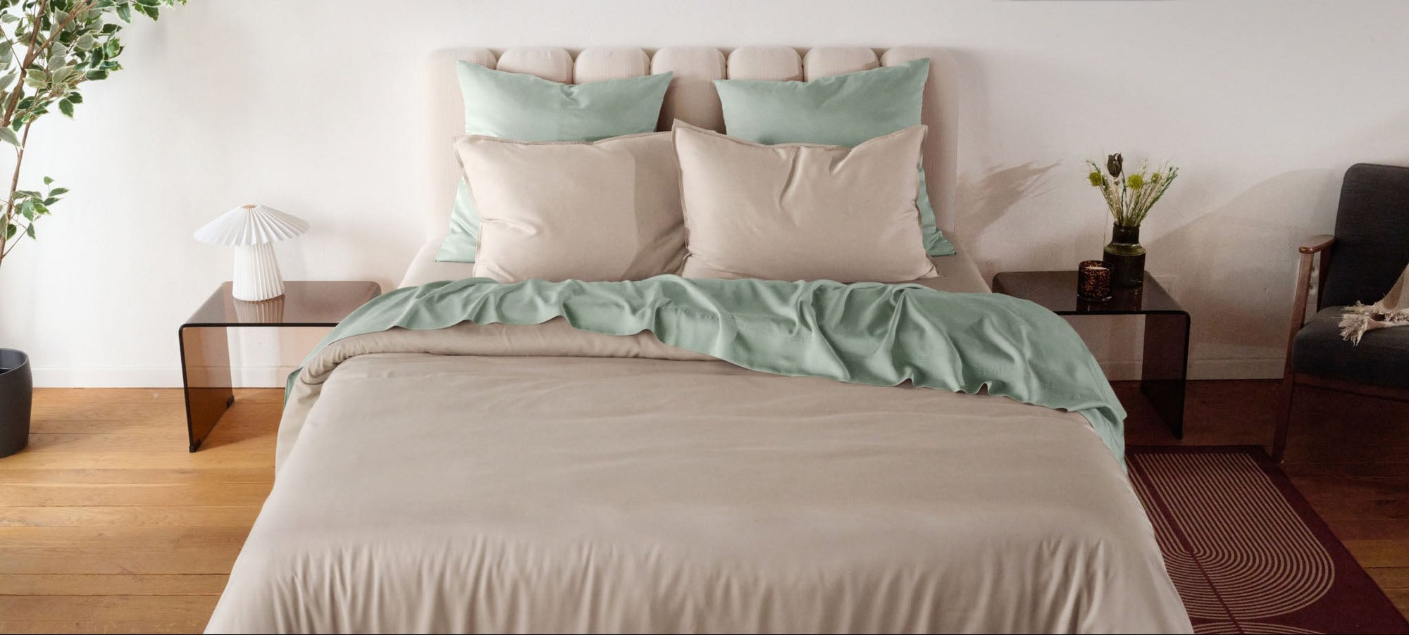 Neatly made bed with light green and beige Bambaw Cozy bamboo bedding in a bedroom setting