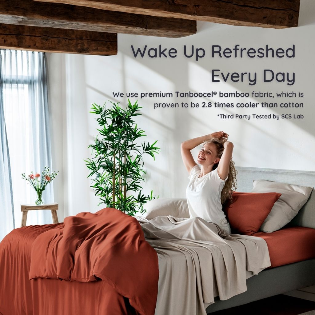 Woman waking up in a bright bedroom in a bed with bambaw cozy bamboo bedsheets in terraccota and sand colours with natural light and plants.