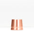Copper safety razor stand on white surface with packaging box in background
